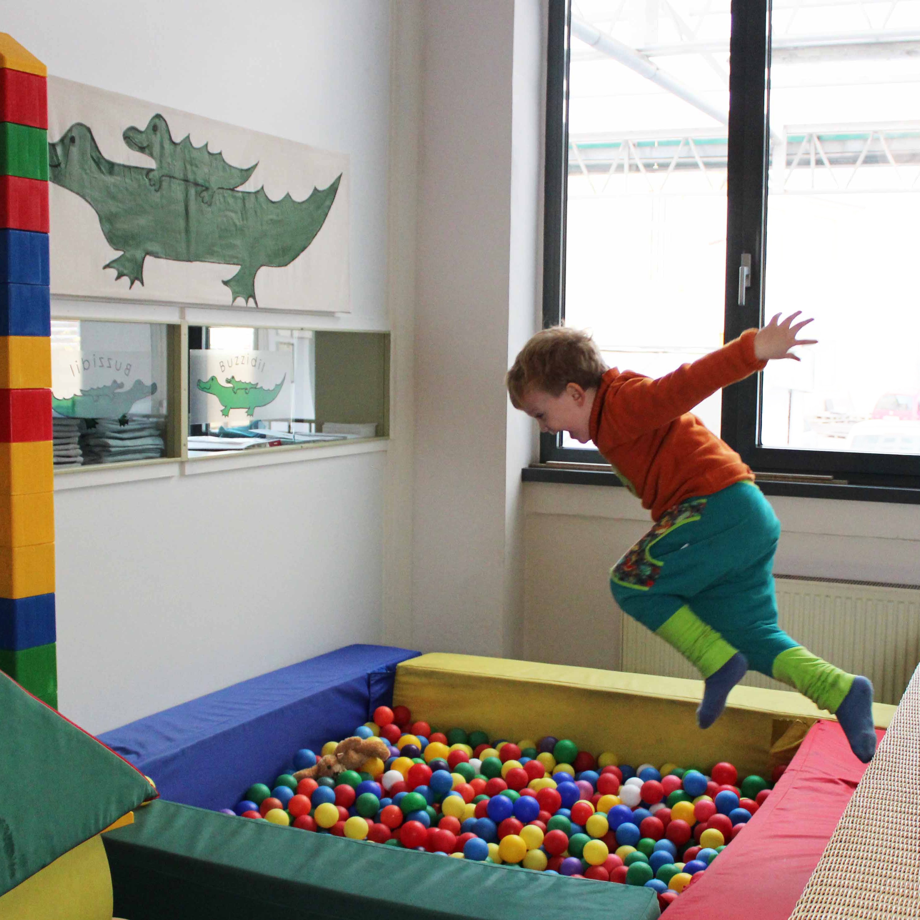 Enfant qui joue dans la pisicne à balles dans les locaux de Buzzidil