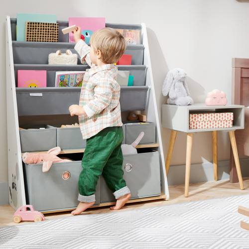 Petit garçon qui range ses jouets dans le meuble de rangement RACOON Kinderkraft
