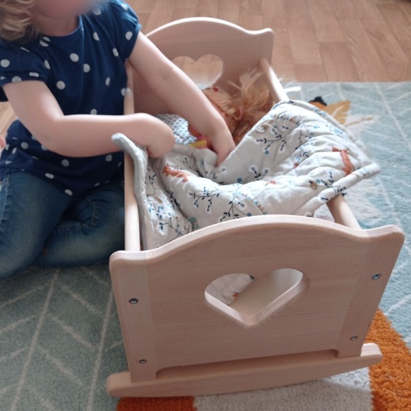 Enfant jouant avec le berceau lobito et une poupée