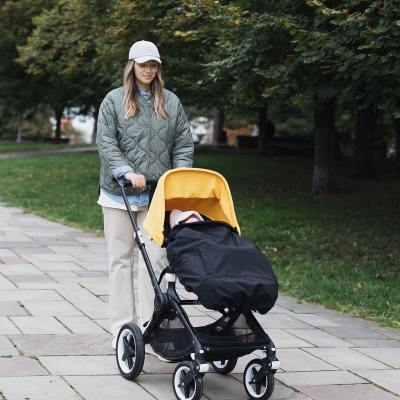 Love & Carry Couverture de portage toutes saisons en softshell noir mise en place sur une poussette