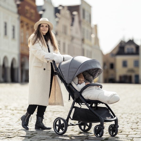 Bébé installé dans une poussette avec une chancelière pendant une promenade hivernale
